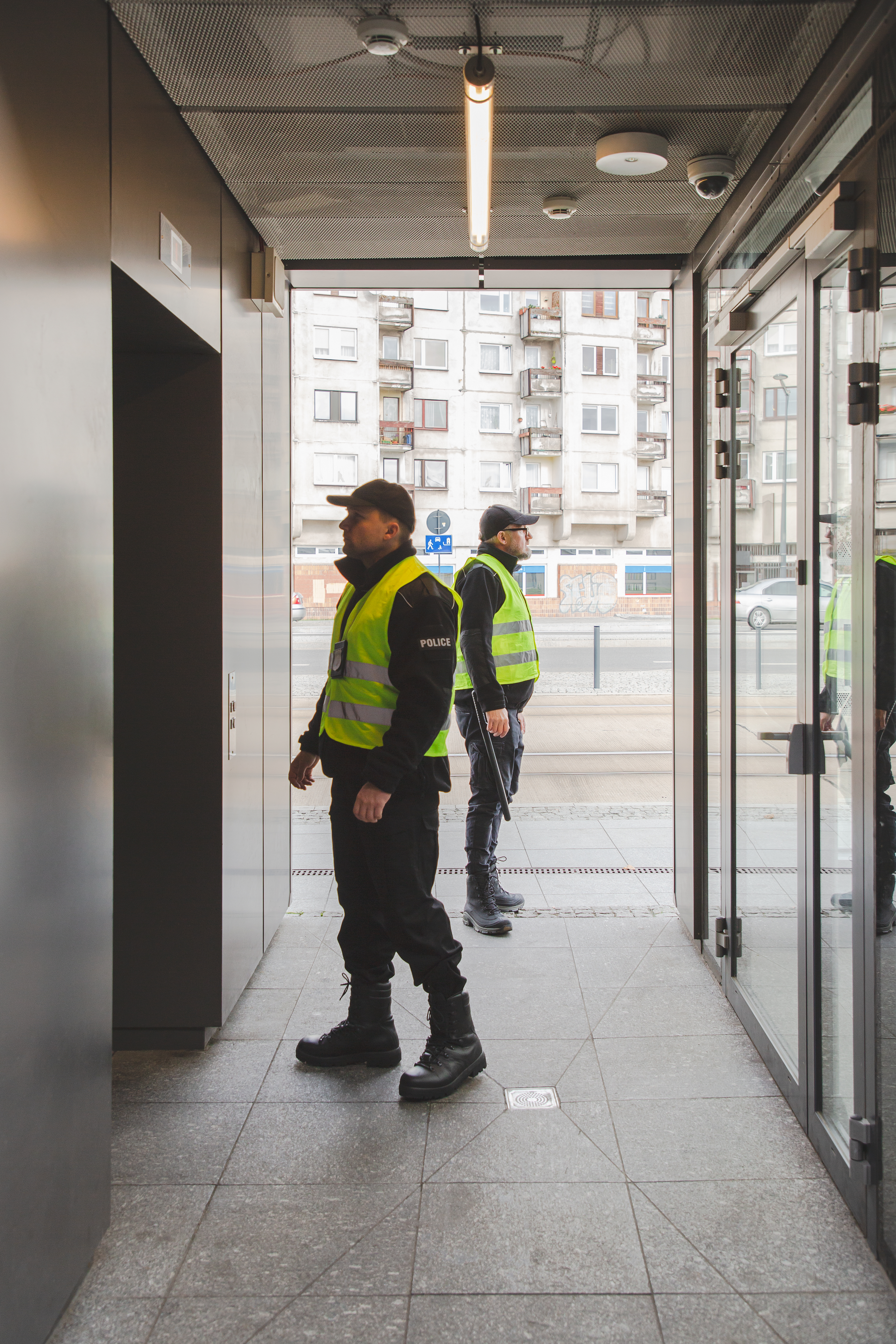 Two policemen in uniforms searching the building looking for  a suspect